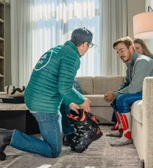 Ski Butlers technician fitting boots in a guest accommodation