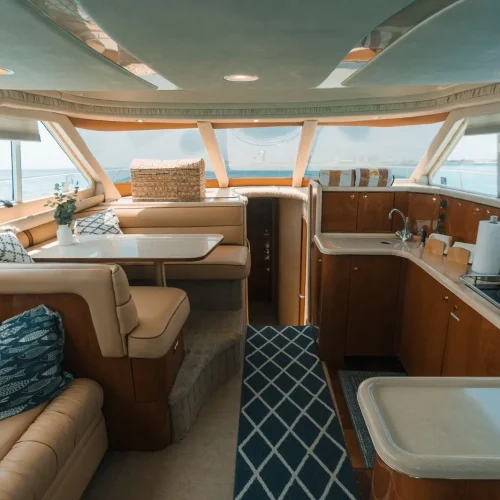 Yacht interior with dining booth, galley kitchen, and leather seating with ocean views.