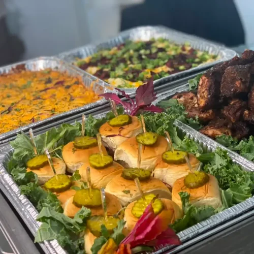 Slider sandwiches, jerk chicken, and casserole trays catering spread