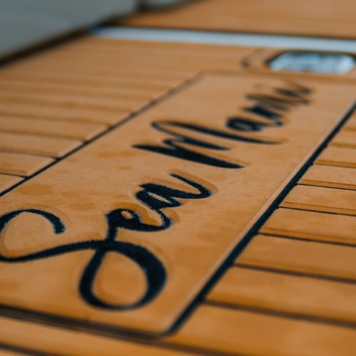 Close-up of Sea Mania name engraved on the yacht teak deck flooring.