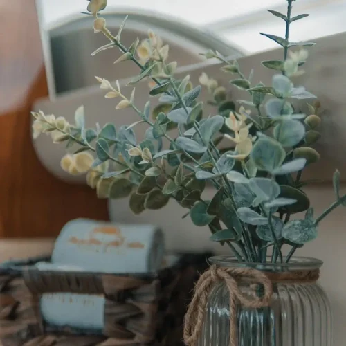 Eucalyptus in glass jar and woven basket decorate yacht interior.