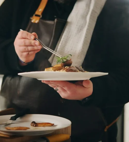 Chef, plate and hands of man with food in kitchen of home for diet, private service or nutrition. Ingredients, recipe and preparation with dish in house for gourmet cuisine, hospitality and lunch